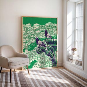 May include: A framed art print featuring a green and white illustration of a cityscape with two pigeons perched on a decorative element. The artwork has a vintage aesthetic, with a wooden frame and a green background.