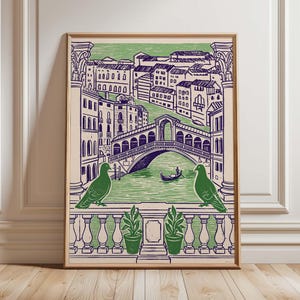 May include: A framed art print depicting a stylized view of Venice, Italy. The print features the Rialto Bridge, buildings, and a canal with a gondola. Two green birds perch on a railing in the foreground. The color palette includes green, blue, and beige.