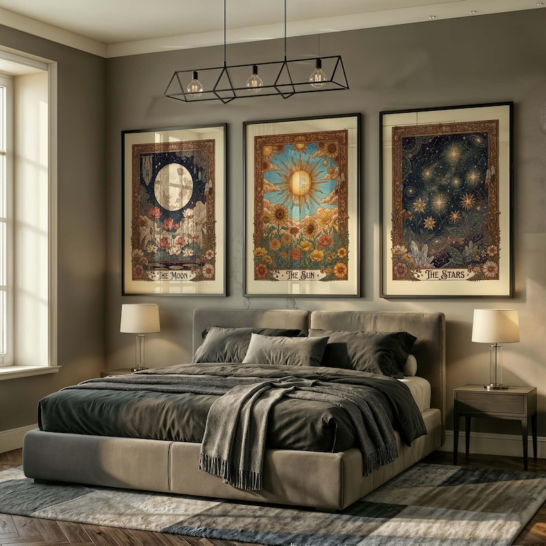 Puede incluir: Tres impresiones art&iacute;sticas enmarcadas que representan temas celestiales: la luna, el sol y las estrellas. Cada impresi&oacute;n presenta ilustraciones detalladas con elementos florales y el cuerpo celeste respectivo. La obra de arte cuelga sobre una cama con ropa de cama gris.