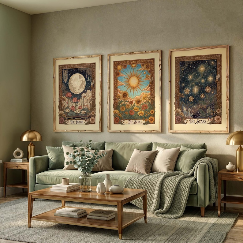 Puede incluir: Tres impresiones art&iacute;sticas enmarcadas que representan temas celestiales: la luna, el sol y las estrellas. Las impresiones presentan ilustraciones detalladas con elementos florales, exhibidas sobre un sof&aacute; verde.