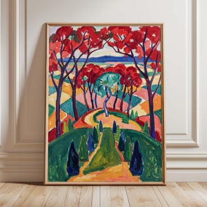May include: A framed landscape painting with vivid colours. The artwork shows a winding path through a garden, with red-leafed trees and a blue sky in the background. The painting is in a gold frame.