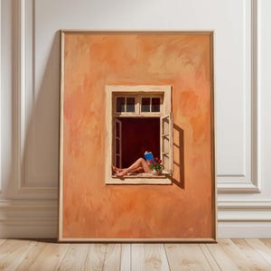 May include: A framed painting depicts a window scene with a person reading a book. The window is open, revealing legs and a blue book. A small vase of red flowers sits on the windowsill. The wall is painted in shades of orange.