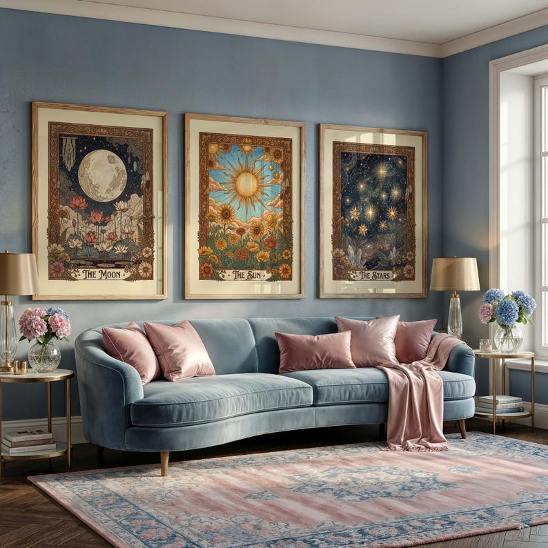 Puede incluir: Tres impresiones art&iacute;sticas enmarcadas que representan temas celestiales: la luna, el sol y las estrellas. Se exhiben sobre un sof&aacute; de terciopelo azul con cojines rosas y una manta a juego. Una alfombra estampada y mesas auxiliares con l&aacute;mparas completan la decoraci&oacute;n.