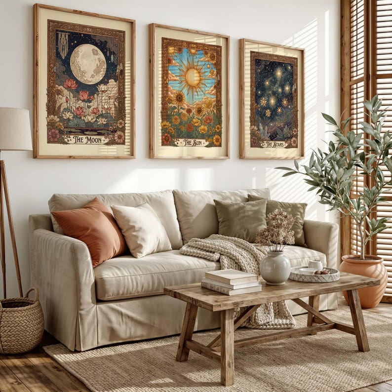 Puede incluir: Tres impresiones art&iacute;sticas enmarcadas que representan temas celestiales: la luna, el sol y las estrellas. Cada impresi&oacute;n presenta intrincados detalles florales y bot&aacute;nicos con una est&eacute;tica vintage. Las impresiones se exhiben sobre un sof&aacute; beige.