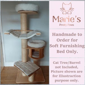 May include: A cat tree with multiple levels, a sisal-wrapped central post, and wooden platforms. It has a hammock, a round bed, and a square bed, all with light-coloured, soft cushions. The image includes text that says "Marie's Pretty Paws" and "Handmade to Order for Soft Furnishing Bed Only."