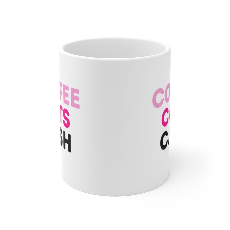 May include: White ceramic coffee mug with the text "Coffee Gets Me Through" in pink and black lettering.