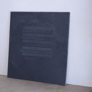 Puede incluir: Un panel rectangular gris oscuro con cinco l&iacute;neas horizontales en relieve.