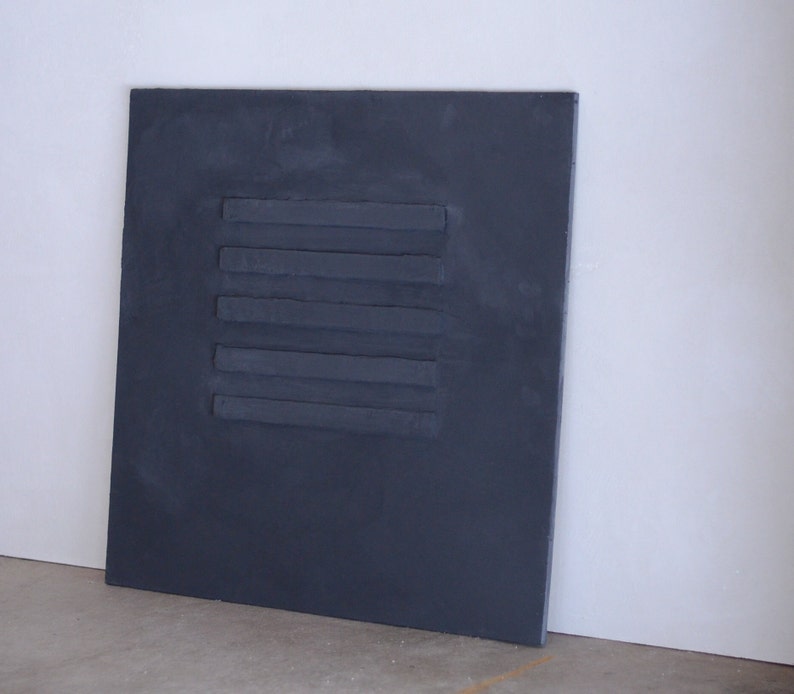 Puede incluir: Un panel rectangular gris oscuro con cinco l&iacute;neas horizontales en relieve.