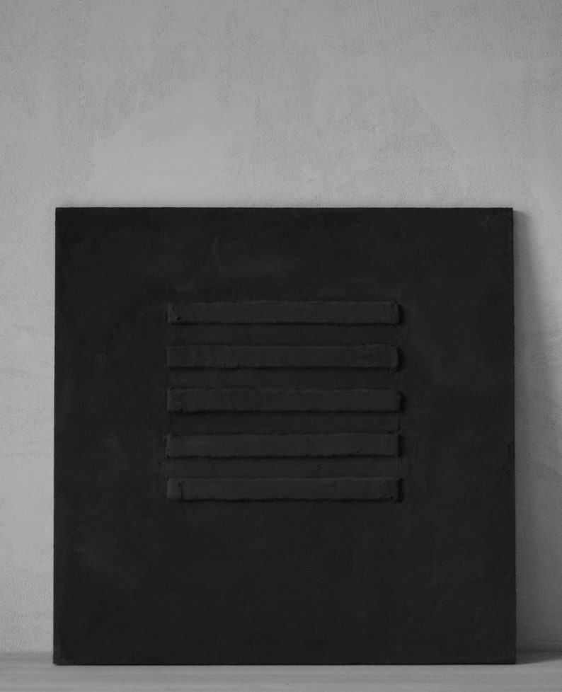 Puede incluir: Un lienzo cuadrado negro con un dise&ntilde;o en relieve de seis l&iacute;neas horizontales.