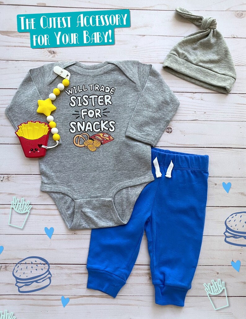 May include: A gray baby bodysuit with the text "WILL TRADE SISTER FOR SNACKS" and a matching blue pants set. The set includes a gray knotted hat and a pacifier clip with a star and french fry design.