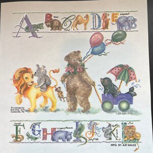 May include: A colorful alphabet print featuring animals and balloons. Each letter is decorated with a different animal, such as a bear, camel, elephant, lion, and more. The print is licensed by Arts Uniq, Inc. Cookeville, TN.