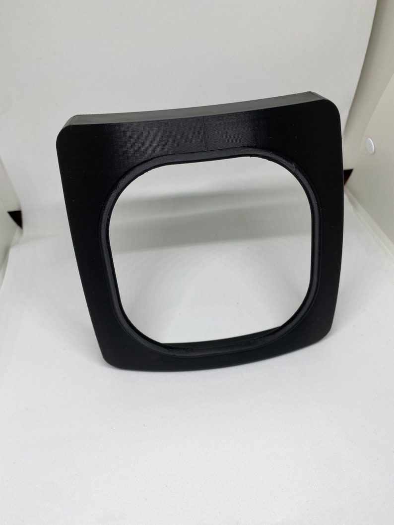 May include: Black plastic frame with a rounded edge. The frame has a slightly raised inner edge.