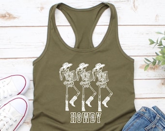 May include: A green tank top featuring a white graphic of three skeletons wearing cowboy hats and boots. The text "HOWDY" is printed below the skeletons.
