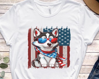 May include: White t-shirt with a cartoon husky wearing sunglasses and a red, white, and blue bandana in front of an American flag.