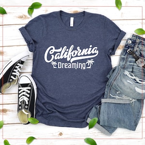 May include: A navy blue t-shirt with white text that reads "California Dreaming" and palm tree graphics.