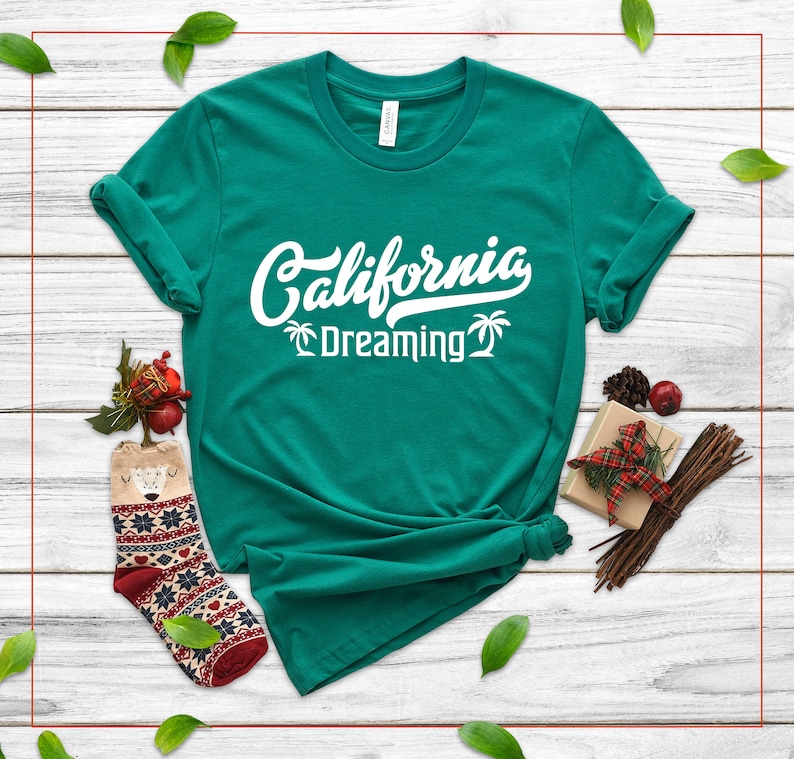 May include: A teal green t-shirt with white text that reads "California Dreaming" with palm tree graphics.