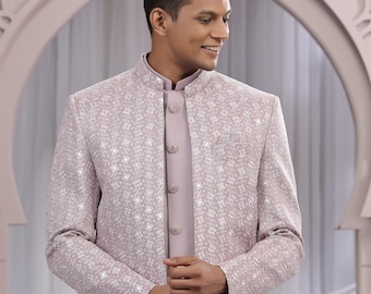 May include: A light purple embroidered jacket with a mandarin collar, worn over a matching shirt with a button-up closure. The jacket features a floral pattern and is paired with white pants. The outfit is formal wear.