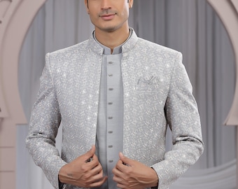 May include: A light gray embroidered jacket and matching shirt with a mandarin collar. The jacket features a subtle floral pattern and a pocket. The outfit is paired with white pants, creating a formal ensemble.