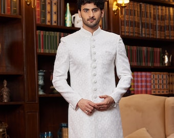 May include: A white long-sleeved kurta with a button-up front and a subtle pattern. The kurta is paired with white pants and black shoes.