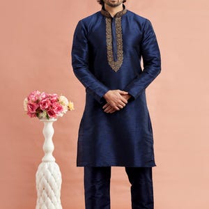May include: A navy blue kurta pajama set. The long-sleeved kurta features intricate gold embroidery around the collar. The matching pajama pants complete the traditional Indian outfit. The number "3123" is visible in the bottom right corner.