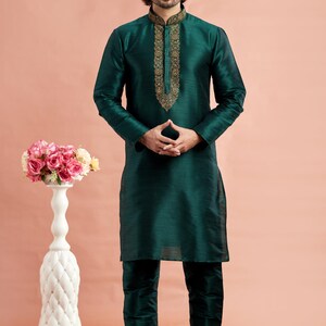 May include: A dark teal kurta pajama set. The long-sleeved top features gold embroidery around the collar and down the front. The matching pants complete the ensemble. The number "3122" is in the bottom right corner.