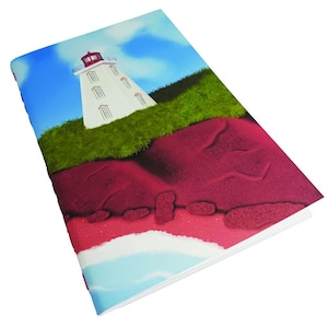 May include: A white lighthouse with a red roof sits on a green grassy cliff overlooking a red and pink sandy beach. The sky is blue with white clouds.