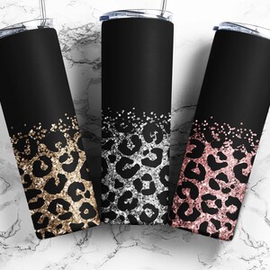 以下が含まれることがあります： 黒色のステンレス製のタンブラー3つ。キラキラしたレオパード柄のデザイン。タンブラーは、ゴールド、シルバー、ローズゴールドのキラキラで飾られています。
