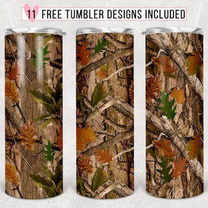 Pode incluir: Três copos de aço inoxidável com um padrão de camuflagem que apresenta folhas marrons, verdes e laranja. Os copos têm uma tampa transparente e um canudo.