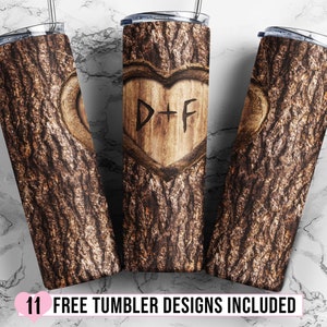 Puede incluir: Tres vasos de acero inoxidable con dise&ntilde;o de veta de madera y un coraz&oacute;n tallado con las iniciales D+F. Los vasos est&aacute;n sobre un fondo de m&aacute;rmol blanco.