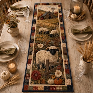 Könnte beinhalten: Ein rechteckiger Tischläufer mit einem aufgedruckten Bauernhofmotiv, das eine Scheune, eine Windmühle und drei Schafe auf einer Weide zeigt. Der Läufer hat einen Rand im Patchwork-Stil mit kleinen Quadraten in Braun-, Rot-, Blau- und Cremetönen.