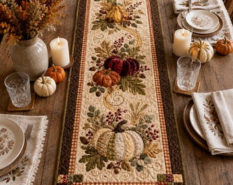 May include: A rectangular quilted table runner featuring an autumn-themed design with appliqued pumpkins, fall leaves, and berries in shades of orange, red, green, and cream, bordered by a dark brown fabric with a small checkered pattern.