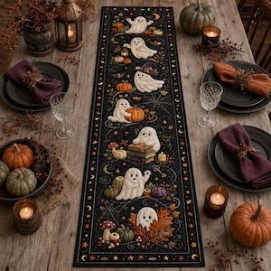 May include: A black rectangular table runner featuring a repeating pattern of white ghosts, orange pumpkins, autumn leaves, mushrooms, and spiderwebs. The design includes various ghost characters interacting with seasonal items like books and lanterns.