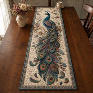 Peut inclure: Un chemin de table rectangulaire orné d'un paon brodé détaillé au plumage bleu, vert et doré vibrant. Le motif comprend des accents floraux sur un fond crème, avec une bordure bleu foncé et un matelassage complexe sur toute la surface.