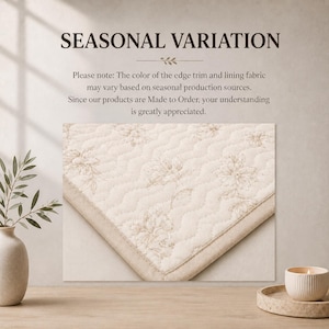 May include: A cream-colored quilted fabric with a subtle floral pattern and a solid border. The text reads: SEASONAL VARIATION. Please note: The color of the edge trim and lining fabric may vary based on seasonal production sources. Since our products are Made to Order, your understanding is greatly appreciated.
