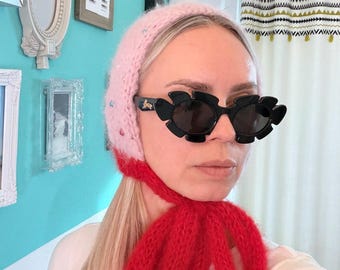 Hand-knitted bonnet with pearls and a large bow
