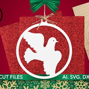 May include: White dove ornament design with a circular frame, set against a red glitter background. A green bow and twine add a festive touch. The image also includes a laser-cut wooden dove ornament and the text "LASER CUT FILES".