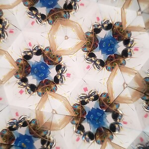 May include: A kaleidoscope image with a repeating pattern of blue, gold, and black shapes. The shapes are arranged in a symmetrical pattern, creating a sense of depth and movement.