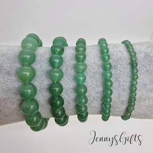 May include: Five green jade stone bracelets of varying sizes. The bracelets are made of round beads and are strung on elastic.