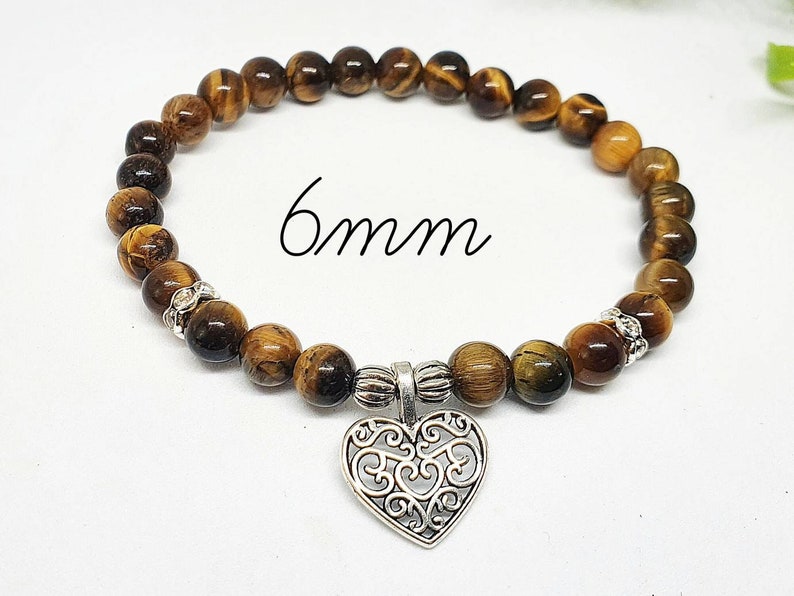 May include: A brown tiger's eye stone bracelet with a silver heart charm. The bracelet has 6mm beads and is made with natural stones.