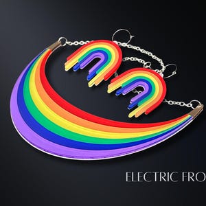 May include: A rainbow-colored necklace and matching earrings set. The necklace is a curved shape with a silver chain, and the earrings are rainbow arches. The text "ELECTRIC FROST" is at the bottom of the image.