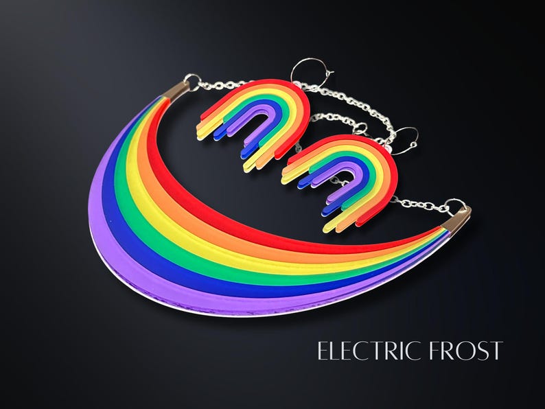 May include: A rainbow-colored necklace and matching earrings set. The necklace is a curved shape with a silver chain, and the earrings are rainbow arches. The text "ELECTRIC FROST" is at the bottom of the image.
