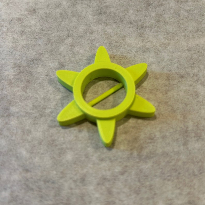 May include: A lime green plastic star-shaped bottle opener with a round hole in the center.