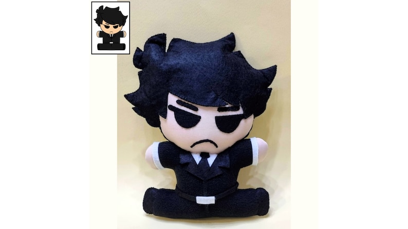 May include: A black felt plush toy of a cartoon character with black hair, wearing a black suit and sunglasses. The toy is sitting with its legs crossed.