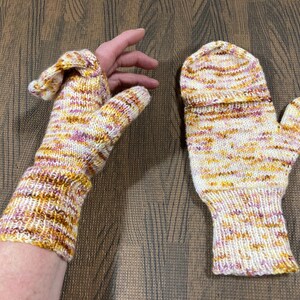 May include: A pair of knitted mittens and fingerless gloves. The gloves and mittens are made of a yarn with a speckled pattern of white, yellow, orange, and pink. The gloves have a thumb and the mittens have a flap that covers the fingers.