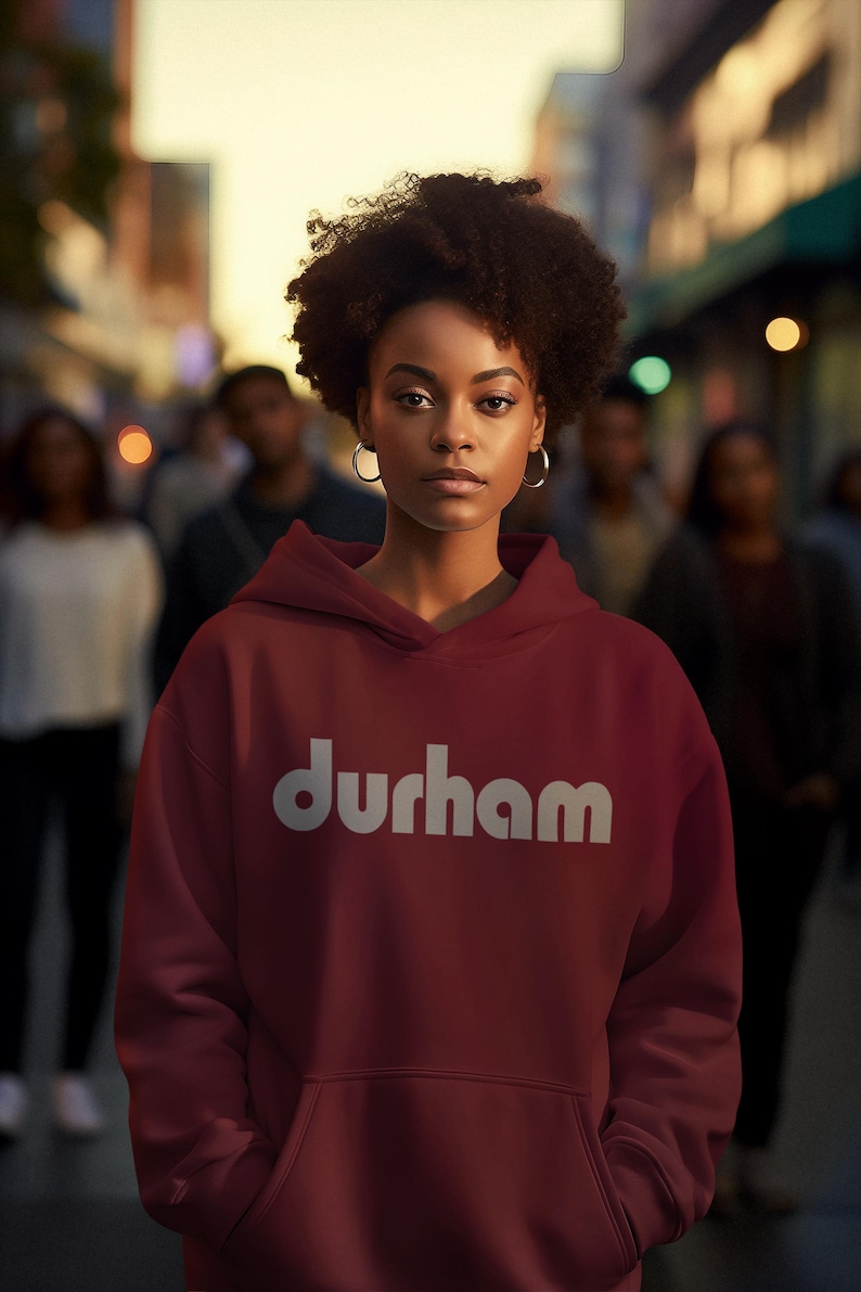 Pu&ograve; includere: Una felpa con cappuccio color bordeaux con un logo bianco "durham" sul davanti. La felpa ha un cappuccio con coulisse e una tasca a marsupio.