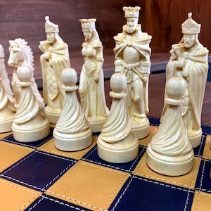 May include: A set of off-white, carved chess pieces arranged on a board with alternating tan and dark blue square tiles. The pieces include pawns with a spiral design, a knight, a bishop, a queen, and a king, all featuring detailed textures.
