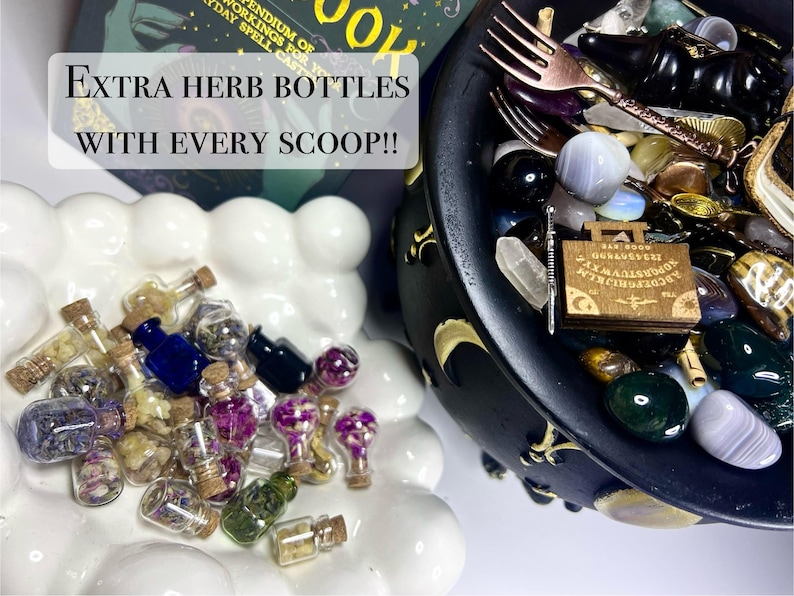 May include: A collection of small glass herb bottles with cork stoppers, in various colors, sits on a white, cloud-shaped dish. A black cauldron filled with crystals, a wooden planchette, and a fork is also visible. Text reads: "EXTRA HERB BOTTLES WITH EVERY SCOOP!!"