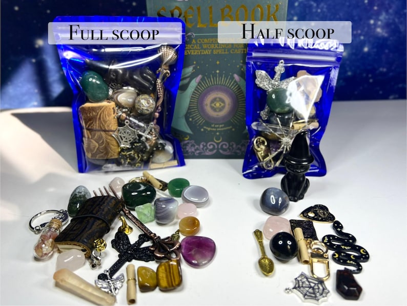 May include: Two blue bags labeled "Full Scoop" and "Half Scoop" filled with assorted crystals, charms, and small objects. A book titled "Spell Book" is visible in the background. Various crystals and charms are scattered in front of the bags.
