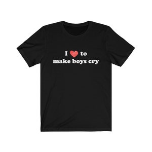 Puede incluir: Camiseta negra con el texto "I ❤️ to make boys cry" en blanco, con un s&iacute;mbolo de coraz&oacute;n rojo. La camiseta tiene mangas cortas y cuello redondo.