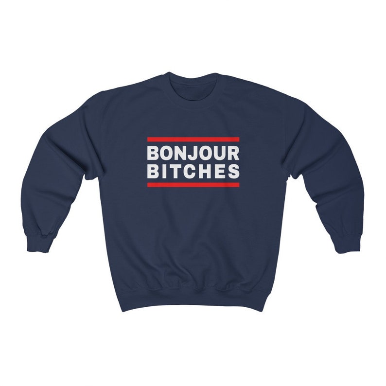 May include: Navy blue sweatshirt with the text "BONJOUR BITCHES" in white, framed by two red lines. The sweatshirt is a casual garment, suitable for everyday wear.
